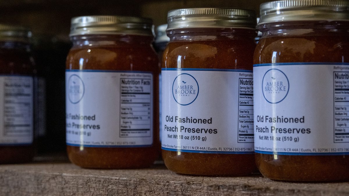 Jars of old fashioned peach preserves on a rustic shelf, ideal for advertisements.
