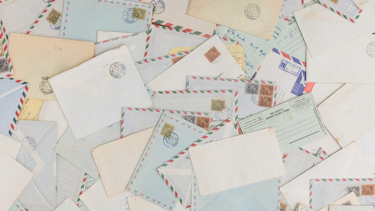 A collection of vintage airmail envelopes and postcards scattered with stamps.