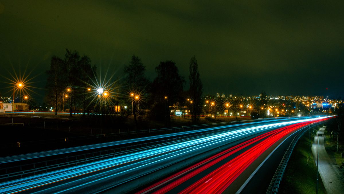 Dynamic light trails on a highway in Jönköping, Sweden, showcasing night traffic and city lights.
