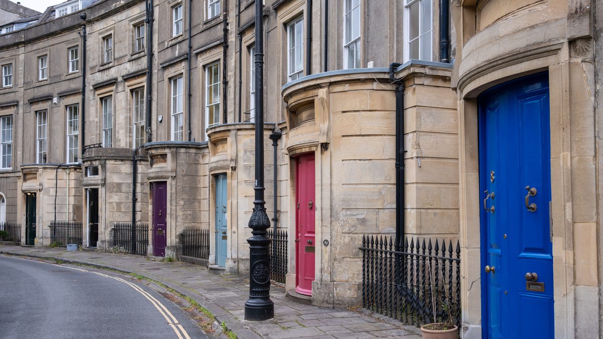 Elegant Georgian terrace houses with vibrant doors in Bath, showcasing architectural charm.