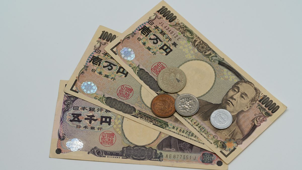 Close-up of Japanese Yen banknotes and coins arranged on a flat surface.