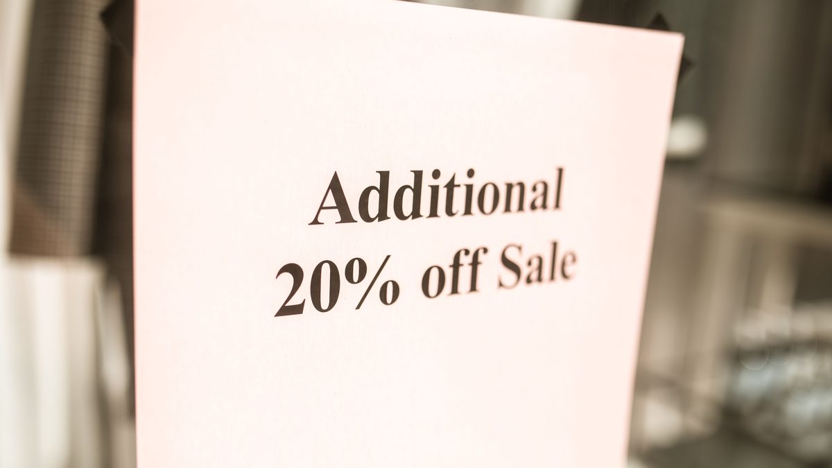 Close-up of a sale sign offering an additional 20% discount in a store window.