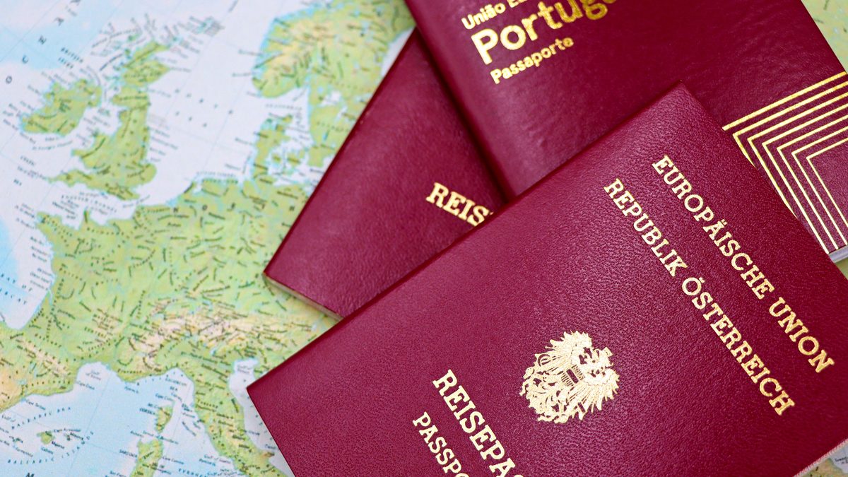 Close-up of European passports from Portugal and Austria on a world map.