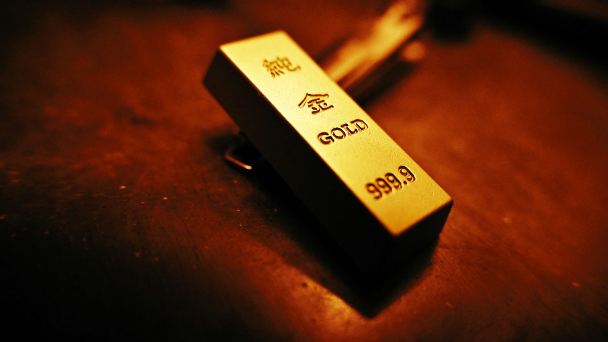 A striking close-up of a gold bar showing inscriptions, captured with warm lighting.