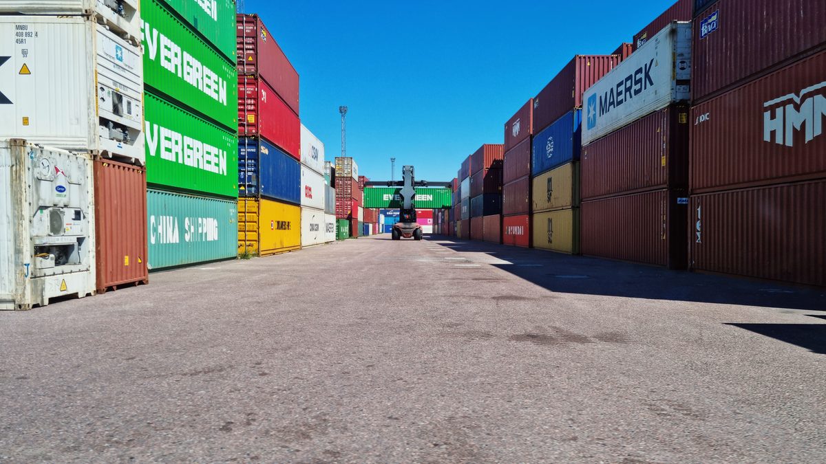 Colorful shipping containers stacked at Muuga Port under a clear blue sky.