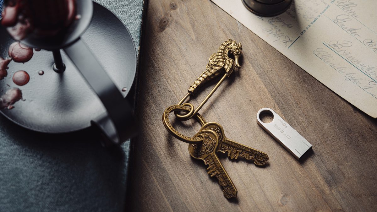 Artistic shot of a vintage seahorse keyring with keys on a wooden table, alongside candle and letter.