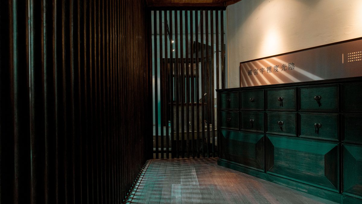A stylish wooden interior featuring a dark cabinet and vertical slatted divider.