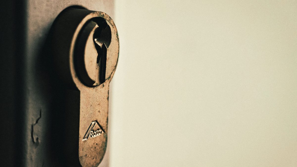 Close-up of vintage keyhole on a weathered wooden door, capturing rustic charm.