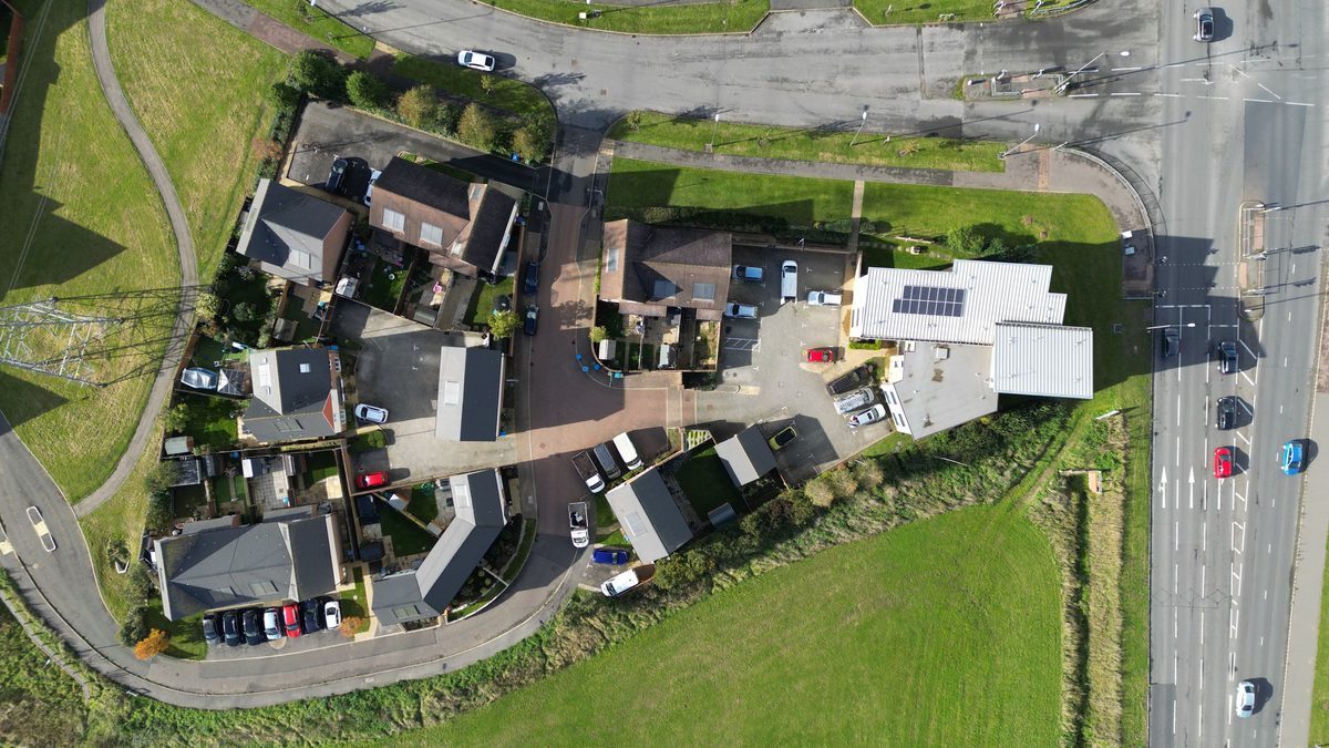 Aerial view of a residential neighborhood in Aylesbury, England, showcasing houses, roads, and parked cars.
