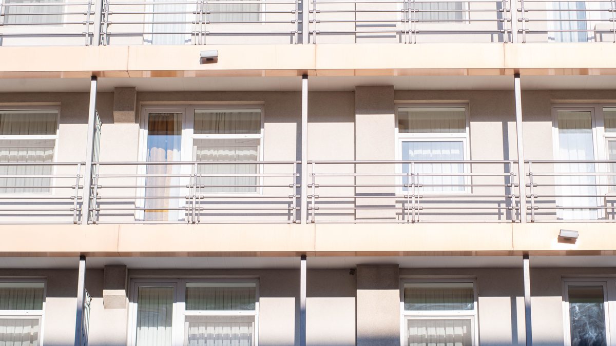 A clean view of a contemporary apartment building exterior showcasing balconies and windows.