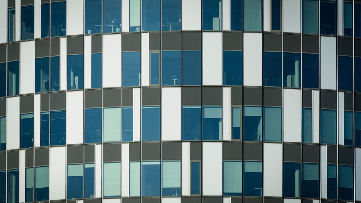 Close-up of a modern office building facade with geometric patterns and glass windows.