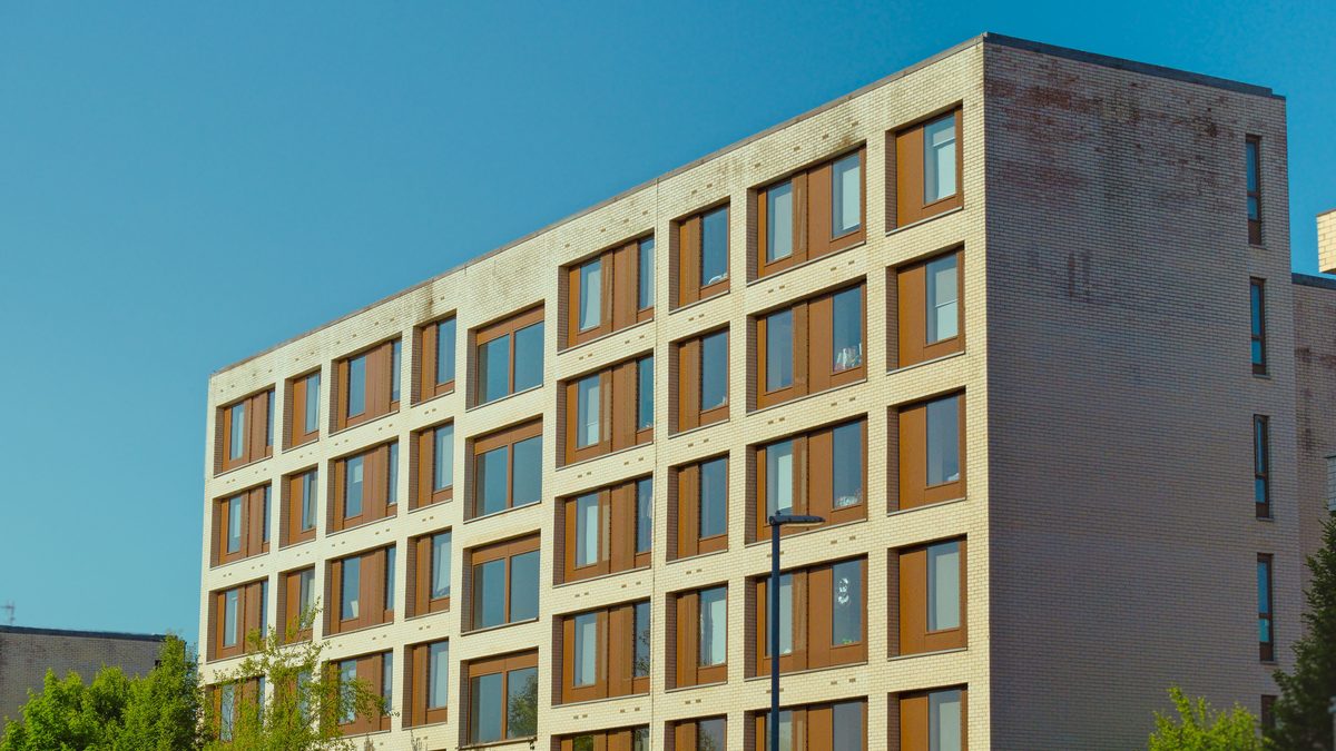 Contemporary brick apartment building against a clear blue sky.