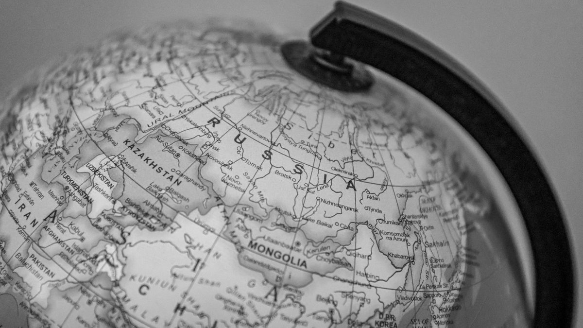 Black and white close-up of a globe focusing on Russia and surrounding countries.