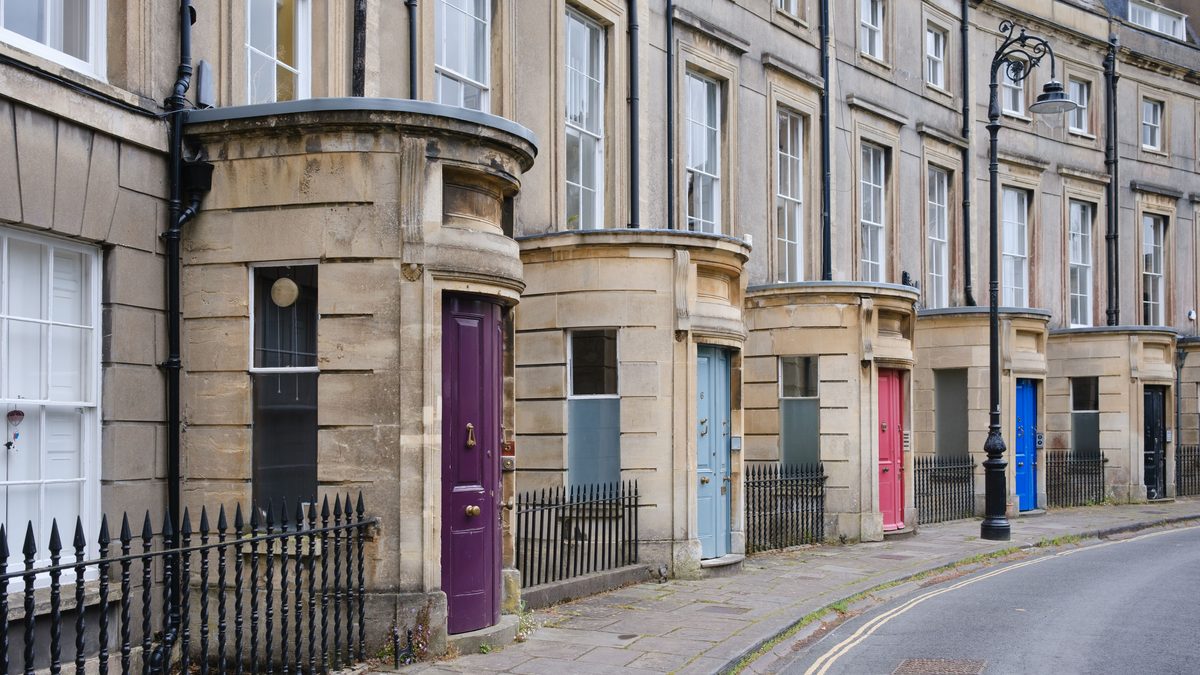 Charming Georgian terraced houses with colorful doors in Bath, England.
