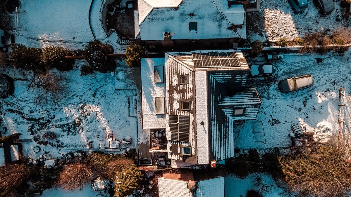 Drone view of snow-covered rooftops in Leatherhead, UK during winter showcasing serene residential architecture.
