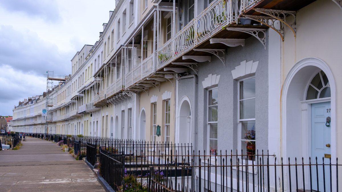 Charming Georgian terraced houses in England with ornate balconies and arches.