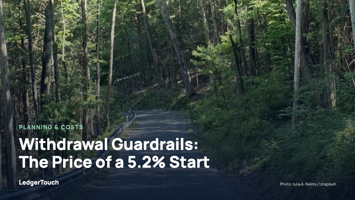 Forest road with a guardrail and dappled sunlight.